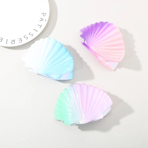 Macro detail of three iridescent shell hair clips with gradient colors and wave textures