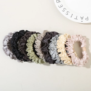 Detail of 8 silk-like satin hair scrunchies in various elegant colors for hair styling