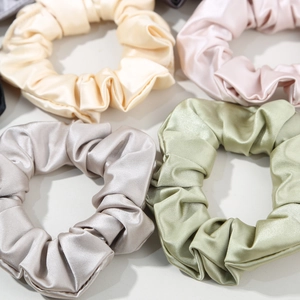 Gros plan de chouchous en satin brillant montrant la texture lisse et les coutures
