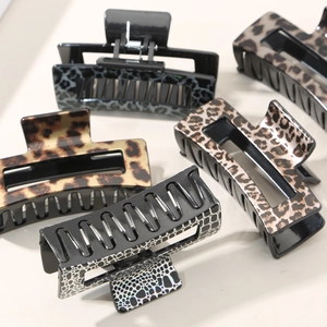 Detail of leopard print hair claws showing large resin textures and metal springs