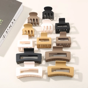 Flat lay of matte shark hair clips in neutral earth tones with a fashion magazine