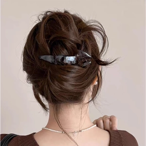 French style dark glossy fishtail hair clip worn on a low bun hairstyle