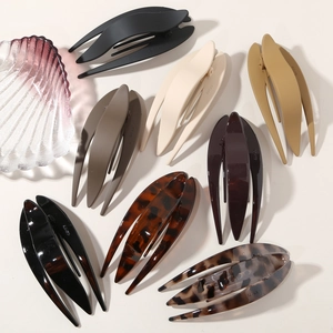 Detail of fishtail-shaped hair clips in matte and glossy finishes for thick hair