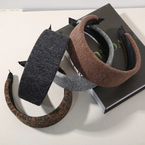 Close-up of wool wide headbands in grey, brown and leopard print on a magazine