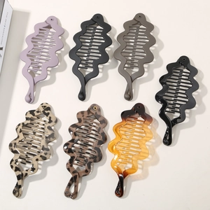 Flat lay showing 7 pieces of stylish matte and leopard print resin banana hair clips