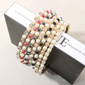 Detailed view of woven crystal beads and pearls on a gold-tone luxury headband