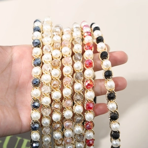 Detail view of multi-color crystal and pearl woven chain headbands with gold alloy base