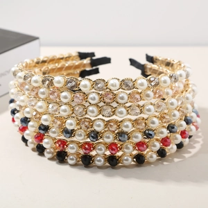 Detailed close-up of woven gold chain headband with crystals and pearls on beige background