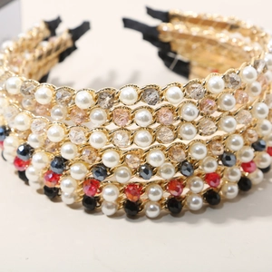 Detail of luxury crystal pearl chain headbands featuring colorful faceted beads and gold metal