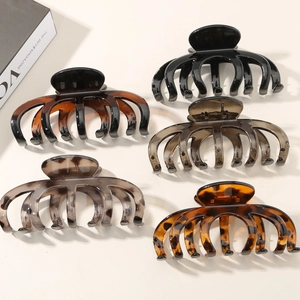 Detailed set of five assorted glossy and matte pumpkin style hair claws on a clean background