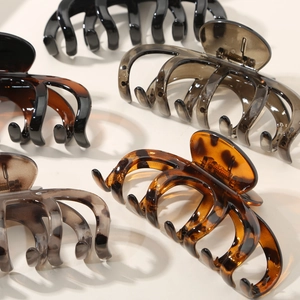 Glossy pumpkin-shaped shark hair clips set in black, amber tortoise, and tea colors