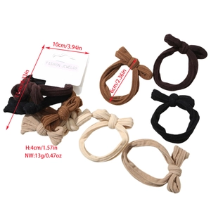 Detail showing five-piece earth-toned bow hair scrunchies with ribbed fabric texture