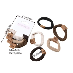 Detail of 5-piece brown hair ties set with cartoon bear leather tags in white packaging