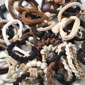 Macro shot of assorted earth-tone elastic hair ties with handmade leather labels