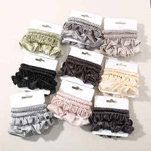 Detail view of 9-color satin scrunchie sets on display cards with elegant silk texture