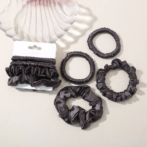 Set of four charcoal grey satin silk scrunchies with elegant glossy texture and ruffles