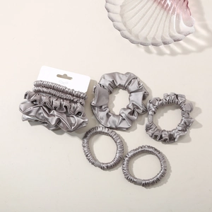 Detailed view of silver satin hair scrunchies set with 5 pieces in various sizes