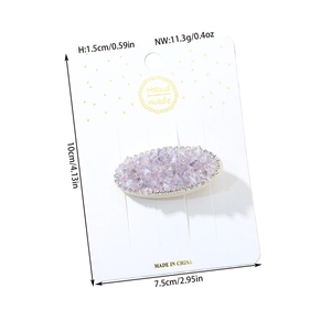 Macro shot of purple crystal hair clip with rhinestone border on handmade display card