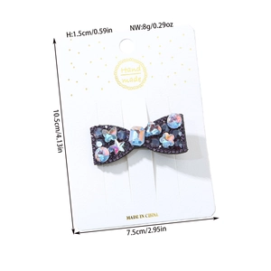 Detailed view of handmade dark purple bow hair clip with colorful rhinestones on card