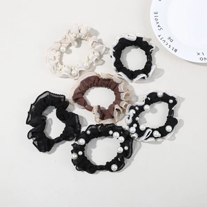 Detailed view of elastic scrunchies set featuring lace edges and pearl embellishments