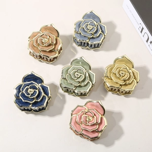 Détail de pinces à cheveux rose avec bordure dorée en marron, bleu, vert et rose pastel
