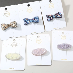 Detailed view of colorful rhinestone hair clips with glittery bow and oval designs