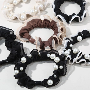 Detailed view of elastic silk scrunchies with white pearls and delicate lace edges