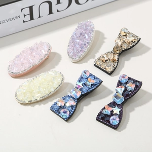 Detailed macro view of colorful crystal hairpins and bow clips on a Vogue magazine background
