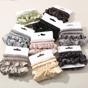 Set of premium satin silk scrunchies in various colors on minimalist white display cards