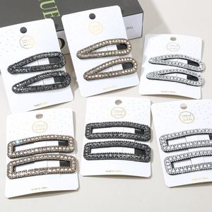 Close-up of sparkling rhinestone hair clip set on white display cards with various designs