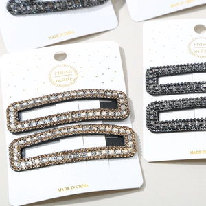 Close-up of handmade sparkling rhinestone hair clip set in gold and grey colors