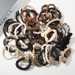 Close-up of handmade earth-toned elastic hair bands with matte beads and woven textures