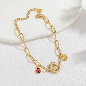 Bracelet doré avec tournesol en céramique, breloques de coccinelle et feuille sur pierre