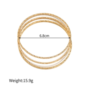 Detailweergave van stapelbare gouden geometrische armbanden met gravures en afmetingen