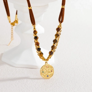 Bohemian double-layer tiger eye beaded necklace with gold medallion on white stand