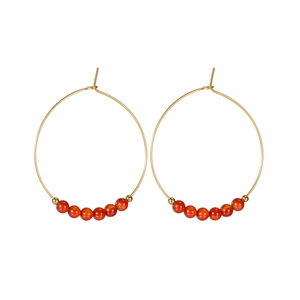 Orecchini a cerchio dorati con eleganti perline rosse dal design geometrico moderno