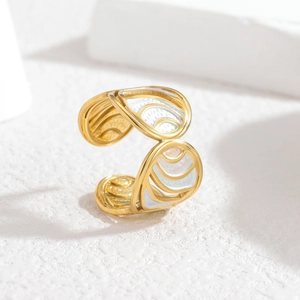 Macro shot of gold-plated open ring with colorful enamel inlay and wave texture