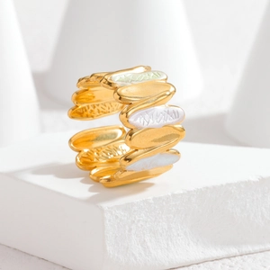 Macro shot of gold plated irregular enamel ring with layered textures and open adjustable band