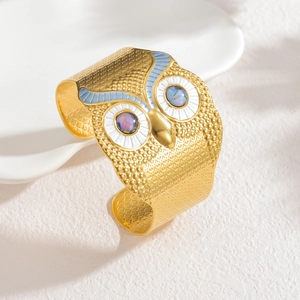 Golden owl-shaped stainless steel open cuff bracelet with blue enamel and shell inlay