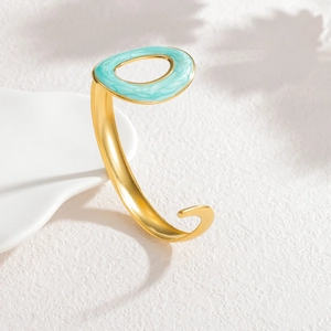 Golden C-shaped enamel cuff bracelet with matte brushed texture and blue marble pattern