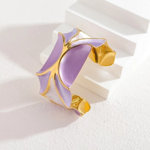 Détail du bracelet manchette large doré à motif ondulé en émail violet et blanc