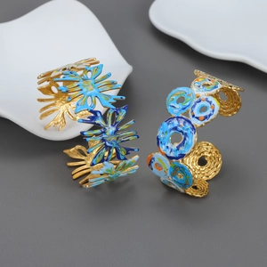 Bracelet jonc ouvert en acier titane doré avec tournesol en émail bleu et géométrie