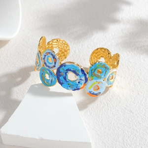 Détails de l'émaillage marbré coloré sur un large bracelet jonc doré tendance
