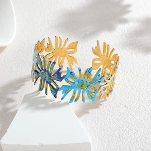 Gros plan détaillé sur le design émaillé bleu floral ajouré d'un jonc ouvert doré