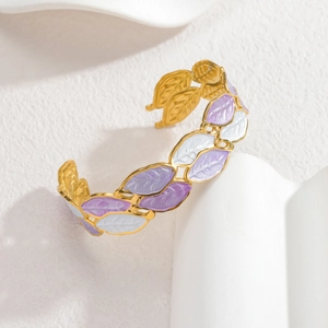 Detail of gold leaf bangle featuring purple and white enamel finish with clear textures