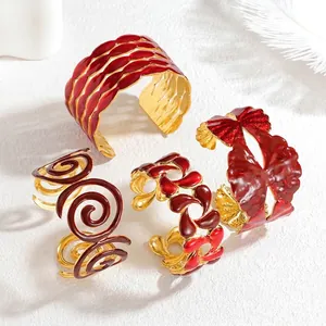 Hollow stainless steel open cuff bracelets with red enamel drip and gold plating finish