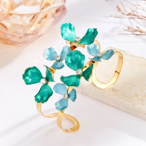 Macro shot of gold-plated bangle with blue enamel flowers and sparkling rhinestones