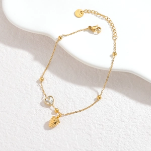 Elegante pulsera de acero inoxidable dorado con cristal de corazón y dijes
