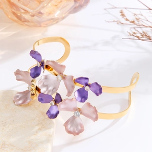 Elegant gold open bangle with purple enamel flowers and sparkling zircon accents