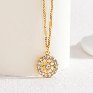 Elegant gold stainless steel necklace with a diamond-studded starburst pendant on display